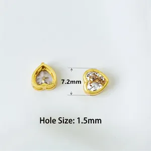Macro detail of heart-shaped gold beads with zircon inlay showing hole diameter measurements