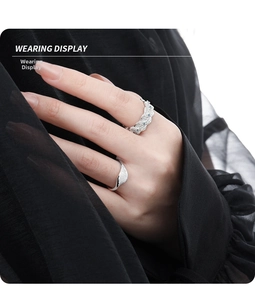 Close-up of S925 silver rings with blue zircon and textured wavy bands on finger