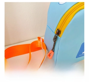 Détail de la fermeture éclair jaune et sangle orange sur un sac enfant en nylon bleu