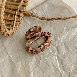 Detail of tortoiseshell resin hair claw with France Handmade stamp on creamy textured paper