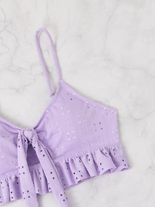 Detail of light purple hollow embroidery crop top with thin straps and ruffled hem design
