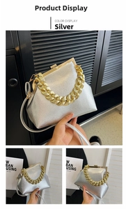 Detail of silver metallic textured handbag with vintage gold chain handle and metal frame