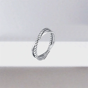 Macro shot of S925 silver ring featuring braided texture and a polished smooth band