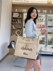 Detail of beige canvas tote bag featuring Summer Nice print and front zipper pocket