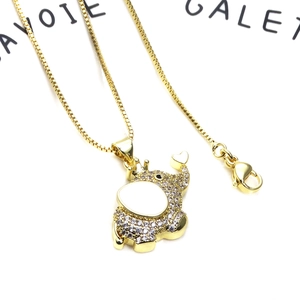 Macro shot of gold elephant pendant with white cubic zirconia and heart detail