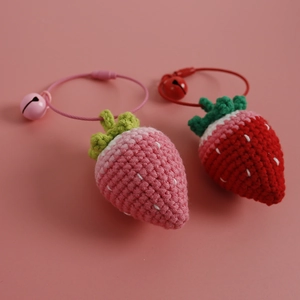 Handmade crochet strawberry charms with bells and wire loops in pink and red colors