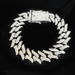 Macro shot of silver hip hop Cuban chain with thorns and sparkling crystal pavé