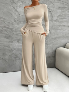 Detail of off-shoulder long sleeve top and wide-leg trousers set in light beige knit