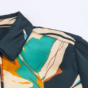 Detail of satin shirt collar with abstract teal and orange prints and fine stitching