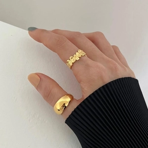 Close-up of minimalist gold S925 silver rings with smooth and textured irregular designs