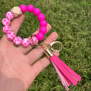 Detail of pink silicone beads, wood bead, and leather tassel on a key ring bracelet