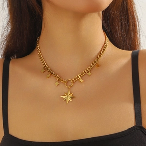 Close-up of golden thick chain necklace with sparkling star pendants on a model