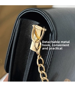 Detail of the golden detachable hardware hook and Saffiano leather texture on a black bag