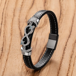 Men's black leather infinity bracelet with silver buckle and blue stones on wooden background