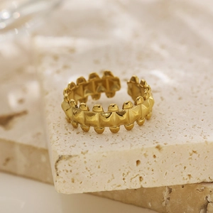 Macro view of adjustable golden metal ring with industrial stud details on travertine stone