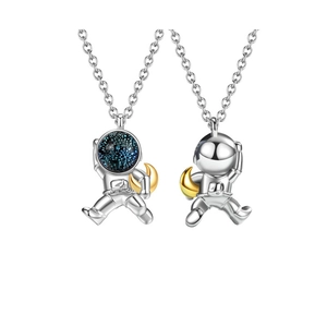 Detailed view of astronaut couple necklace pendants with blue star stones and gold moon accents