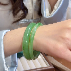 Close-up of dual green resin marble bangles with a smooth glossy finish on model