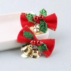 Red velvet Christmas bow with golden bells and green holly leaves decoration