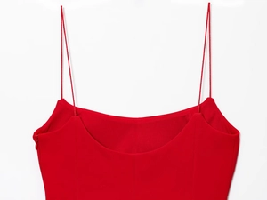 Detail of red camisole top showing slim shoulder straps and high-quality sewing craftsmanship