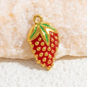 Detailed close-up of a strawberry charm with red enamel and gold-plated metal finish