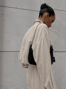 Women's chic beige long sleeve shirt and pants set with a black nylon shoulder bag