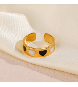Detail of gold-plated heart ring featuring black and white oil drip pattern on silk
