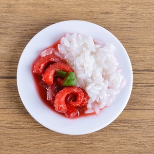Realistic PVC miniature bowl of roast pork with green peppers on a wooden table