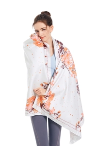 Detail shot of microfibre beach towel featuring orange floral patterns and soft texture