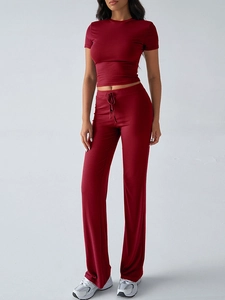 Detail of red two-piece set featuring short sleeve crop top and drawstring waist pants