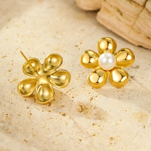 Vintage 18K gold plated stainless steel flower earrings with pearls on stone background
