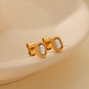 Macro shot of gold stainless steel stud earrings with rectangular white zircon stones