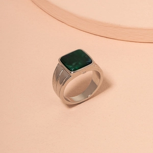Detail of silver ring with square green turquoise stone and textured side bands
