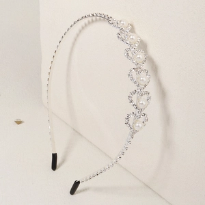 Detail of silver headband with sparkling rhinestones and pearls in heart patterns