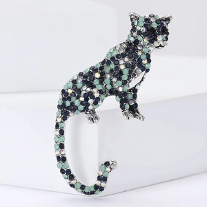 Vintage leopard brooch with blue rhinestones and silver-tone finish on white stand