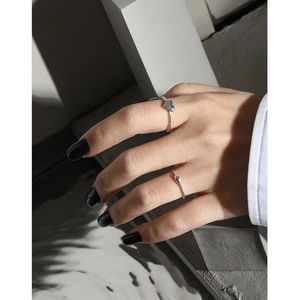 Minimalist S925 sterling silver water drop and heart rings worn in a modern architectural setting