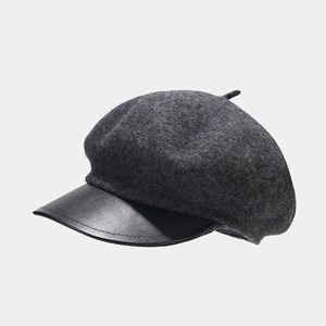Detailed view of the dark grey wool beret with a contrasting black leather brim