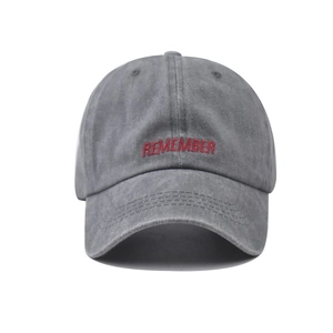 Detail of red Remember embroidery on vintage washed grey baseball cap texture