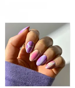 Detail of short round purple and pink gradient press-on nails with polka dot patterns