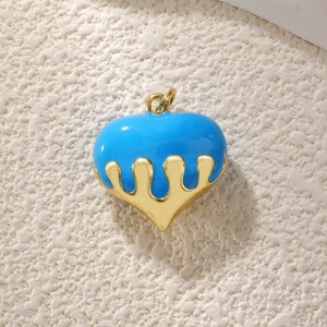 Detailed view of a gold-plated heart pendant with blue enamel and zircon inlay