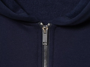 Detail of silver metal zipper and soft navy blue fleece texture on a casual hoodie
