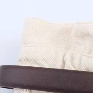 Dettaglio degli shorts paperbag in denim a vita alta con tela crema e cintura marrone