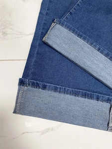 Dettaglio ravvicinato di jeans blu scuro con risvolto cucito e tessuto in denim di alta qualità