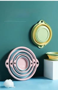 Three sizes of foldable washbasins in pink and green with wall-hanging hole