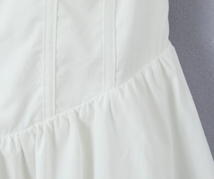 Vue détaillée de la robe blanche avec coutures précises et design de taille plissée