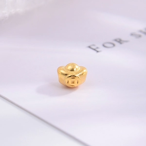 Macro view of a gold-plated Yuanbao ingot spacer bead with traditional coin pattern