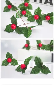 Close-up of artificial red holly berries with green jagged leaves for Christmas decor