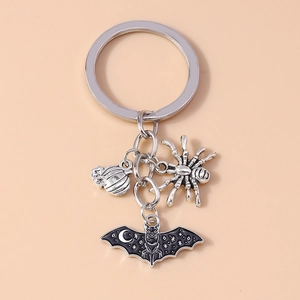 Close-up of vintage alloy keychain featuring silver spider, pumpkin and bat charms