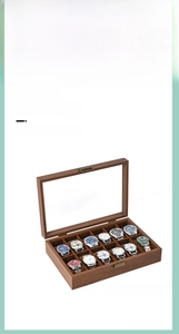 Detail view of a 12-slot walnut watch box with a clear glass lid and soft velvet pillows