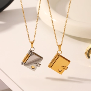 Book pendant necklace in 18K gold and silver tones with hollow heart and hinge detail