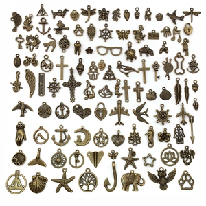 Set van 100 diverse antieke bronzen hangers met verschillende vormen op wit decor